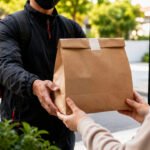 Entregador entrega pacote de comida em casa, representando delivery em casa e início da formalização com CNPJ.